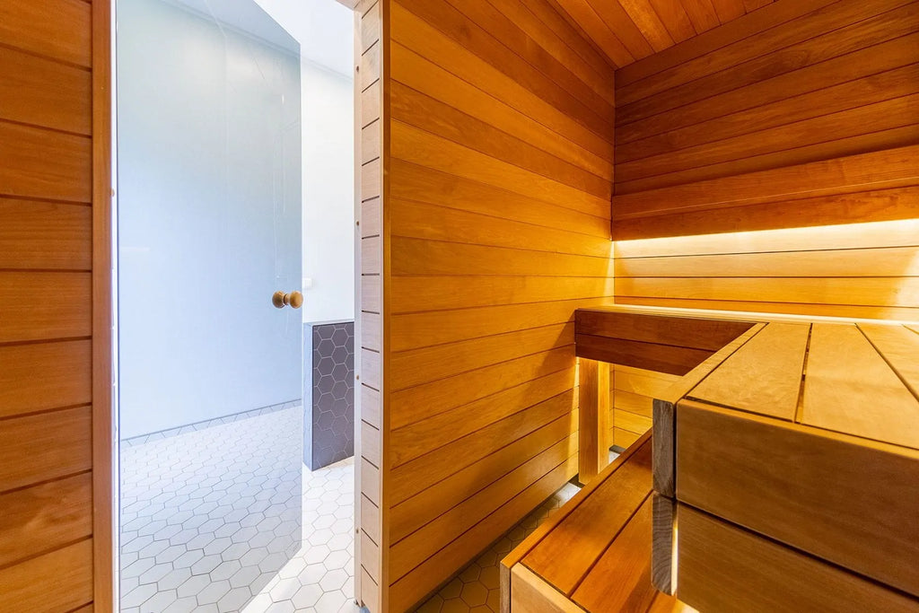 Wooden sauna with benches and a light blue door.